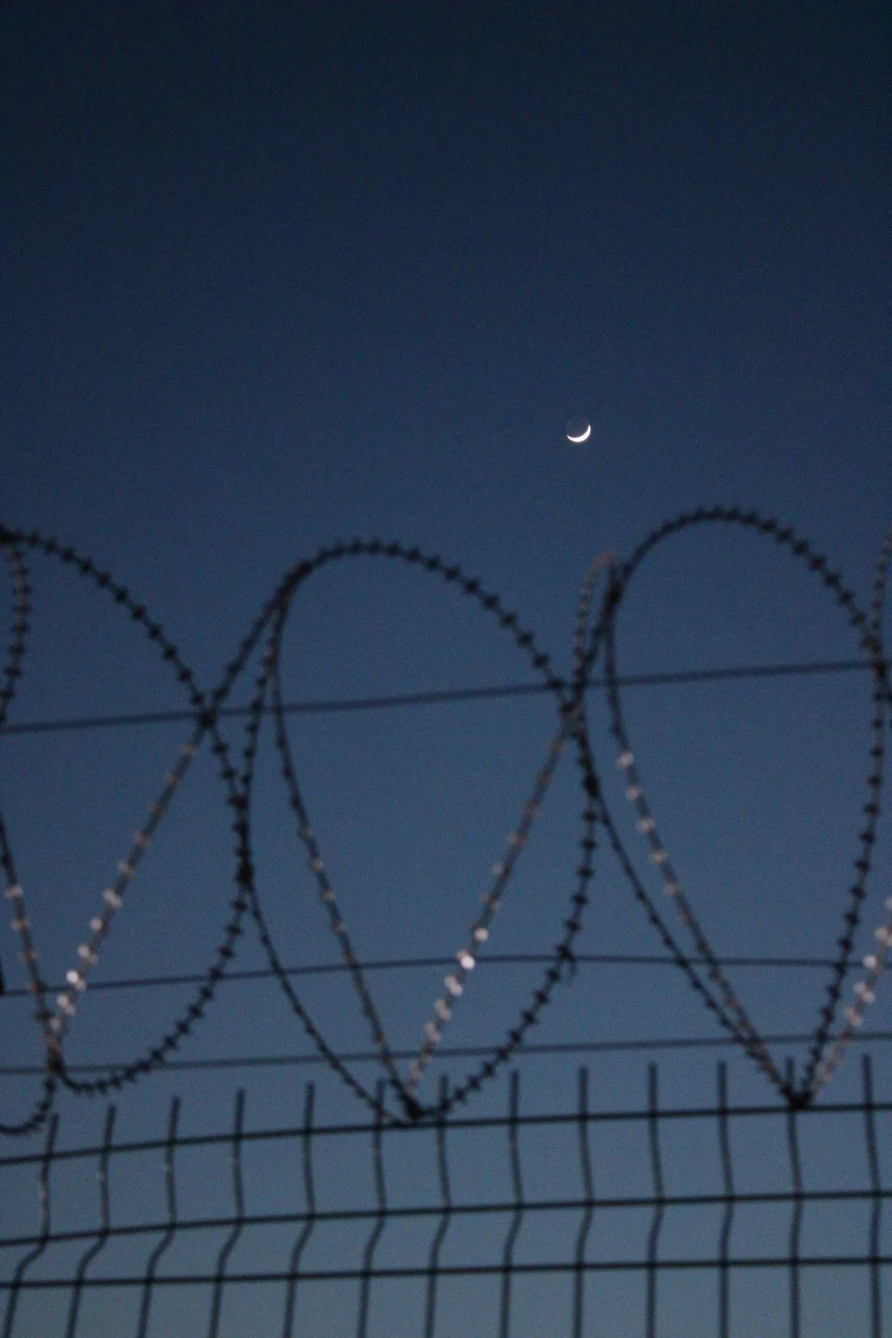 Silueta de alambre de púas nocturno — el escenario central de la seguridad fronteriza y de infraestructuras críticas